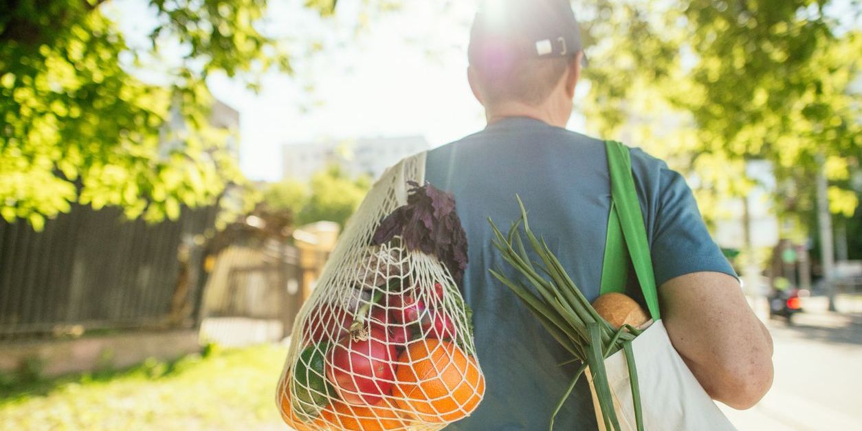 Man carrying fruits and vegetables in reusable shopping bag