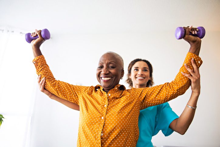 patient lifting weights with physical therapist