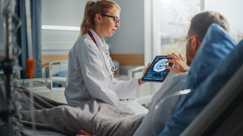 Image of doctor with ipad showing a brain scan to patient