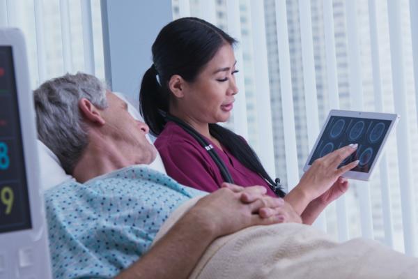 patient lying on hospital bed with a doctor by their side 