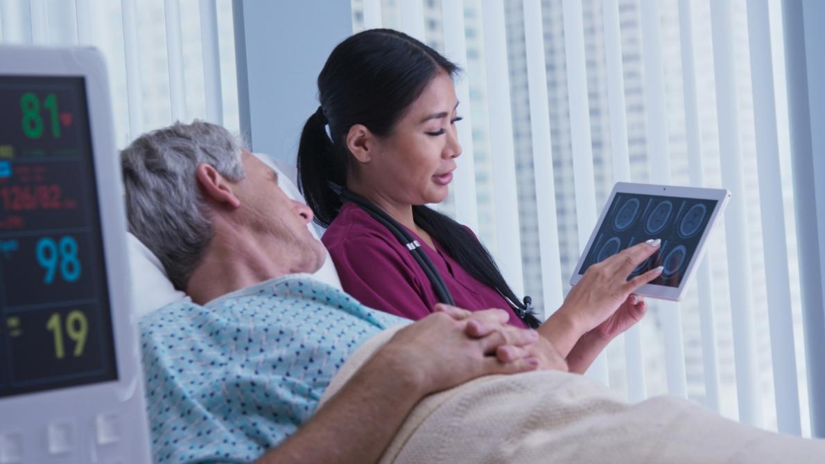 patient lying on hospital bed with a doctor by their side 